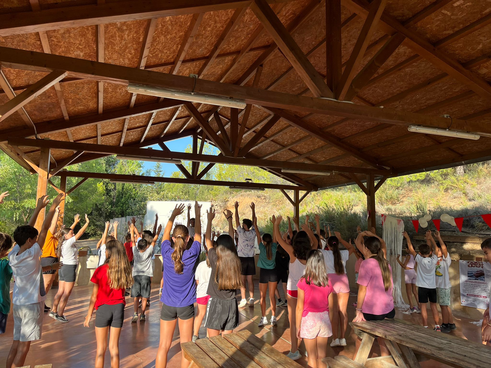 Grupo de niños participando en una actividad física durante un campamento al aire libre.