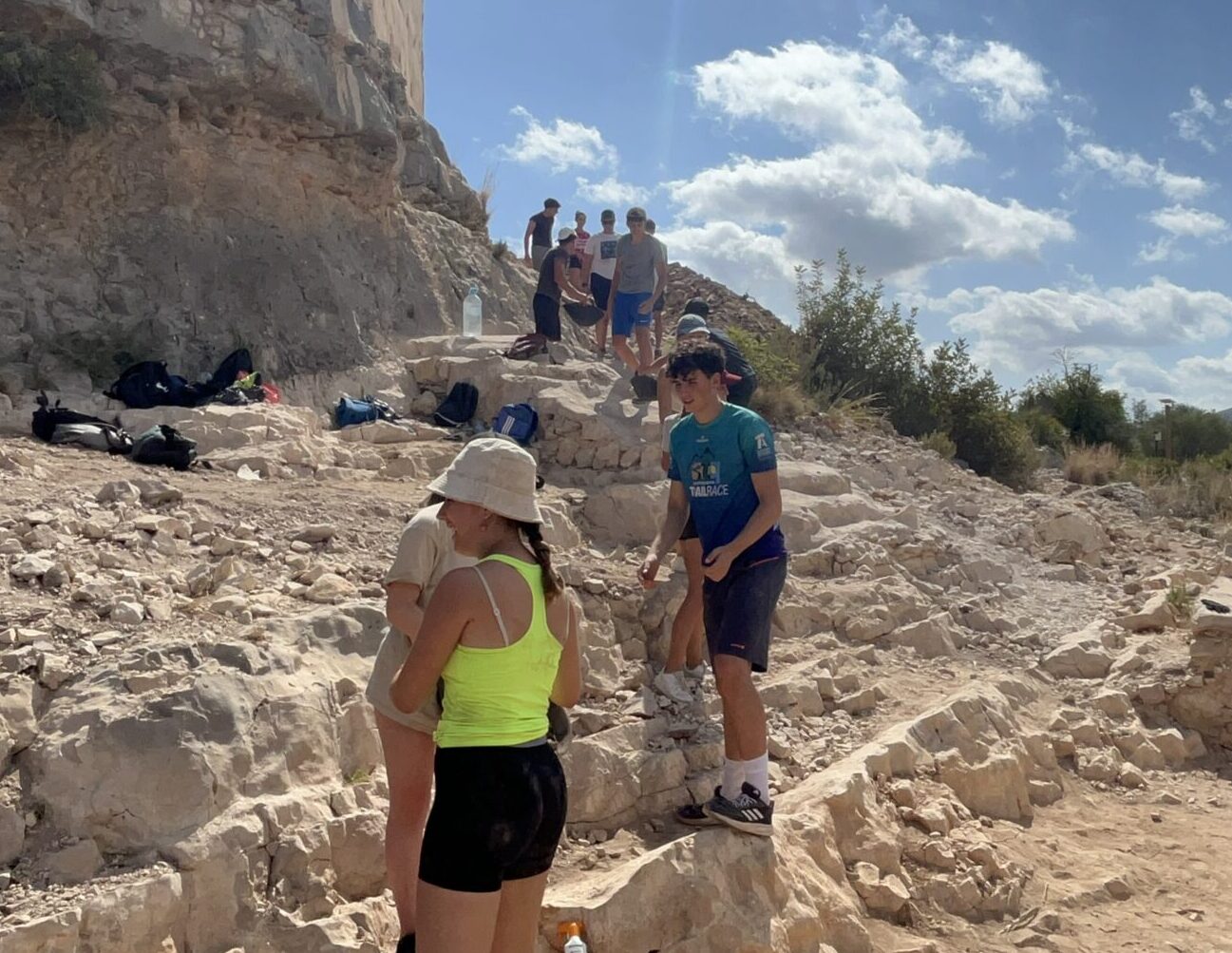 Grupo de adolescentes realizando una excursión al aire libre por un entorno natural, compartiendo una actividad en grupo.